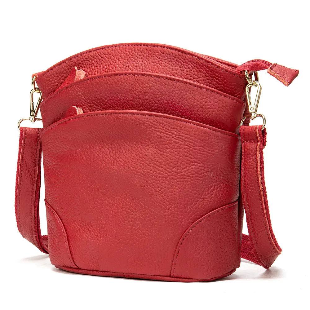 Red textured leather crossbody bag made of retro cowhide with gold-tone hardware and an adjustable strap for shoulder use.