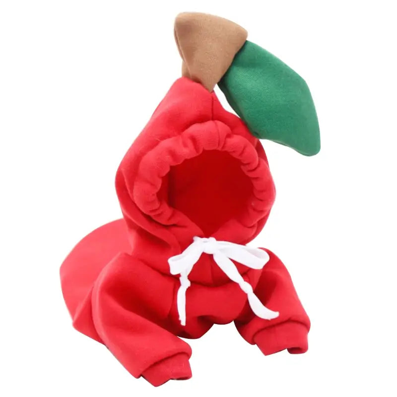 Red apple-shaped pet hoodie in plush fabric with green leaf and brown stem accents on the hood designed for winter clothes.