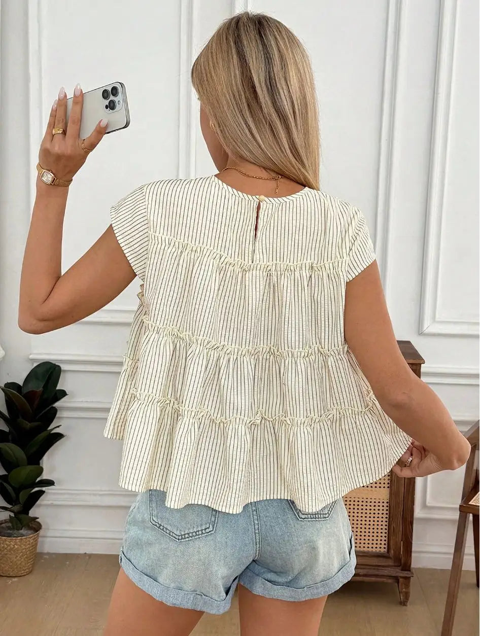 A cream and beige vertically striped tiered short-sleeved blouse with a ruffled hem called tiered striped ruffle hem blouse in beige.
