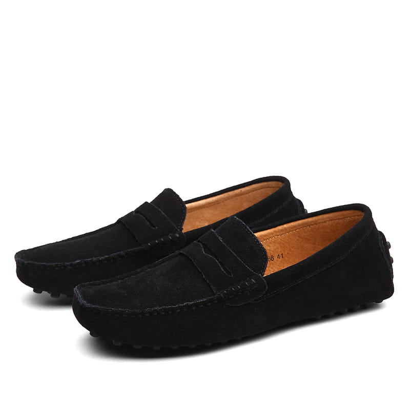 Les mocassins en daim noirs pour homme présentent un design classique avec une doublure en cuir beige et une semelle en caoutchouc durable.