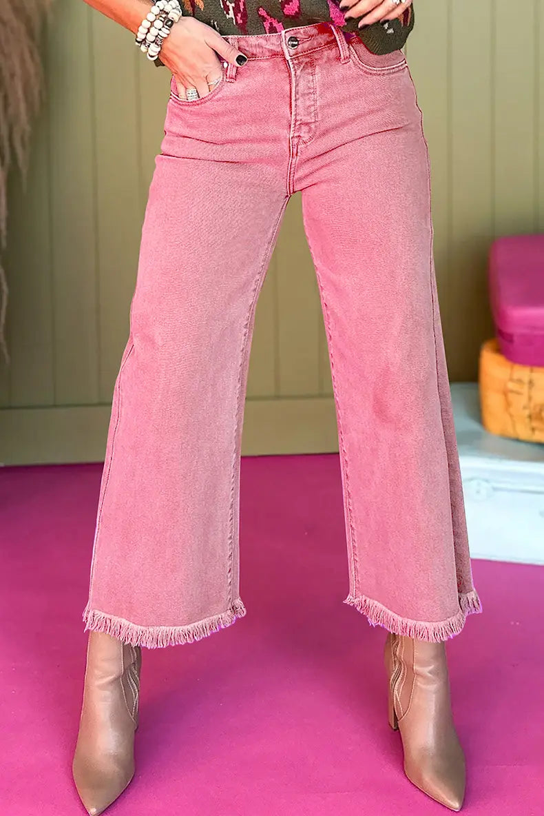 Jean en denim à jambes larges à taille haute rose fabriqué à partir d’un tissu en denim rose, avec des ourlets effilochés visibles sur le côté avant