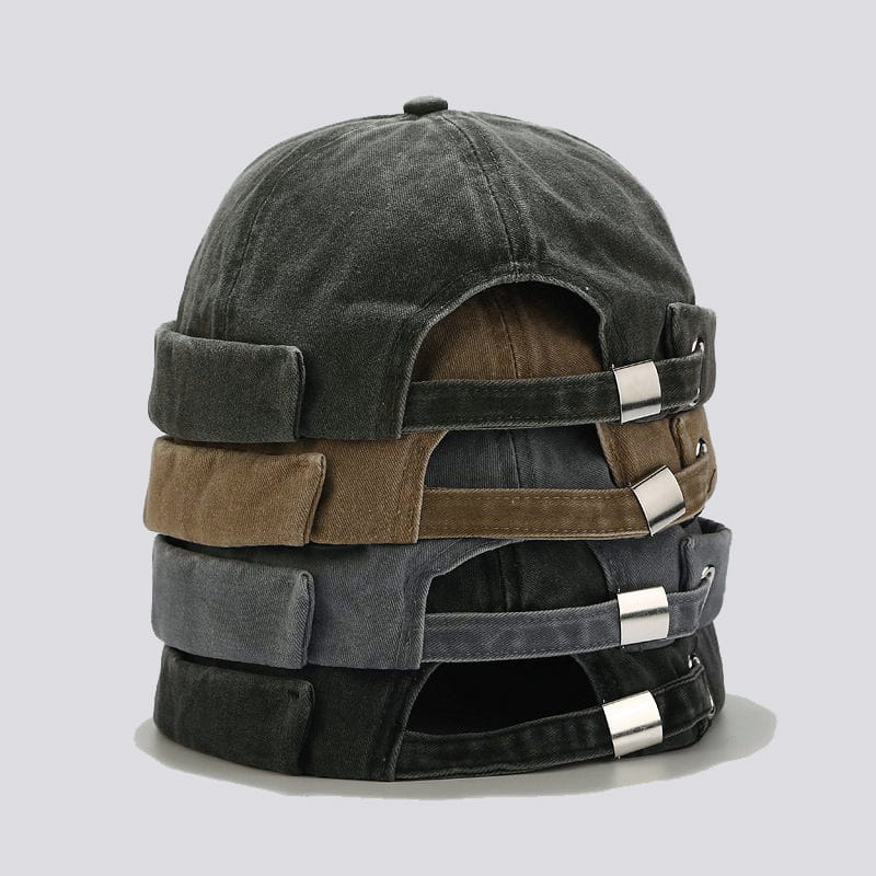 stacked washed denim baseball caps in faded black brown and gray featuring retro rolled brims and silver metal buckles.