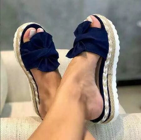 navy blue velvet bow slide sandals with woven espadrille platform soles for women displayed from the back side.