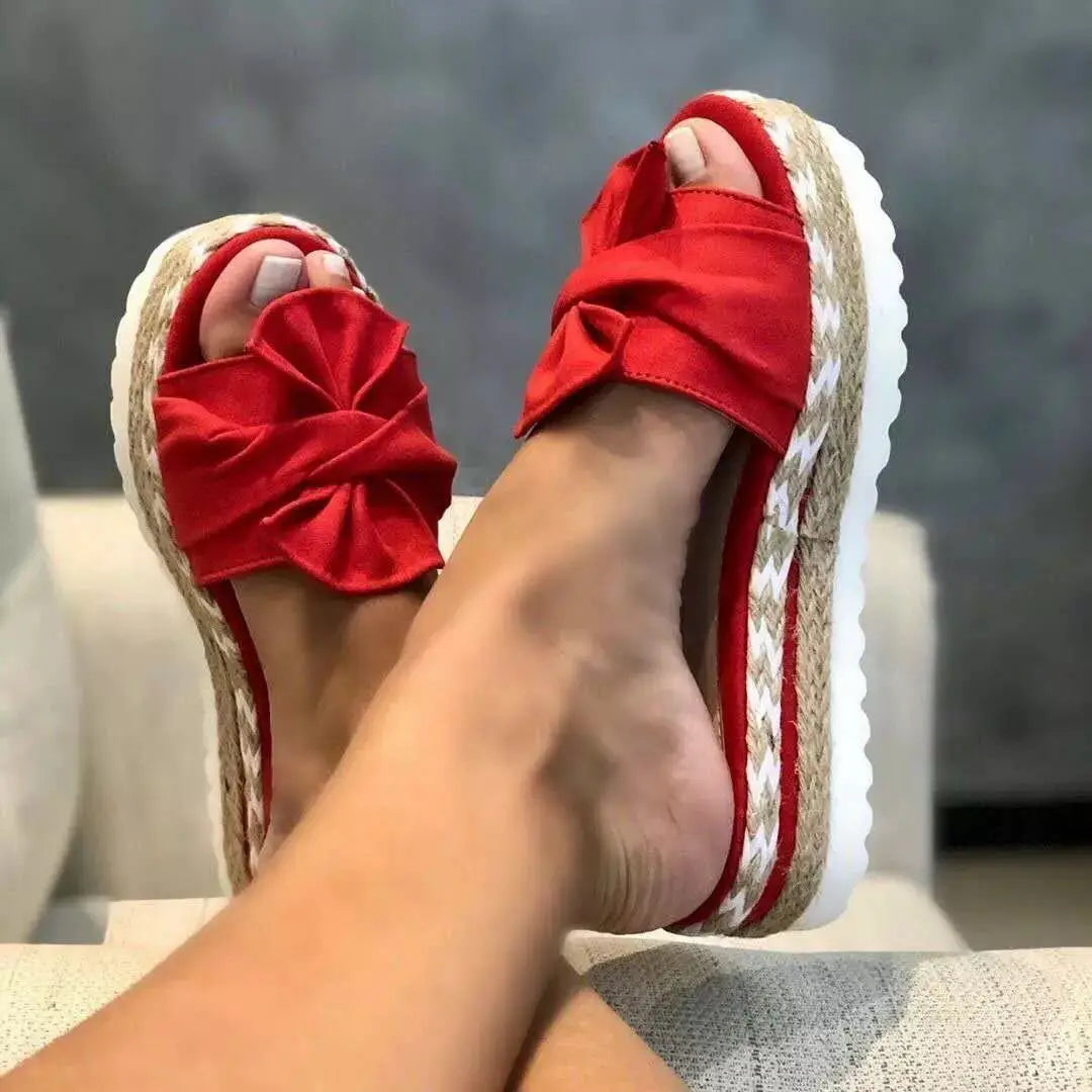 Women platform bow espadrille slide sandals in red fabric with a woven espadrille sole and white platform.