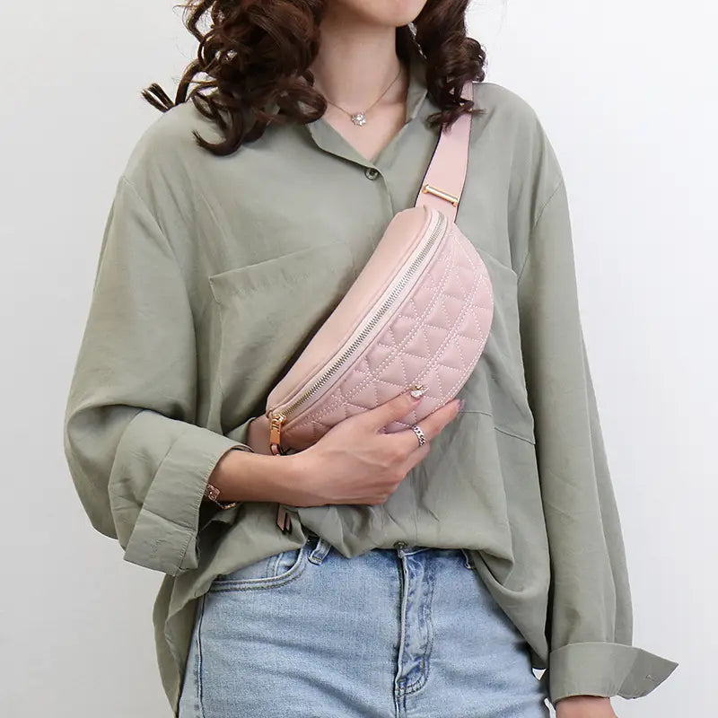 A soft pink quilted faux leather waist bag for women with a gold-toned zipper and matching strap.
