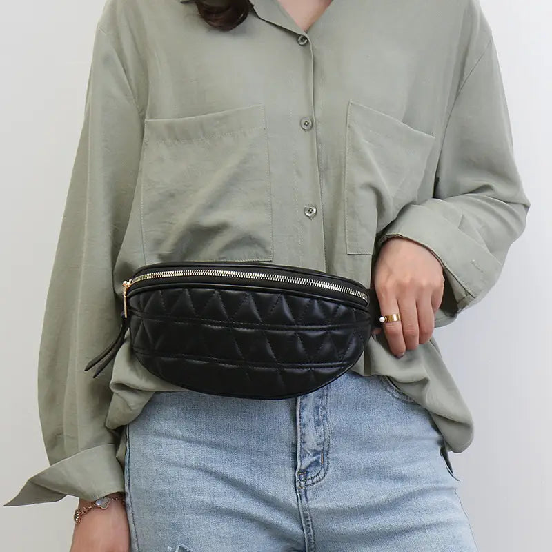 Black quilted faux leather waist bag for women featuring a gold-tone zipper and adjustable strap.