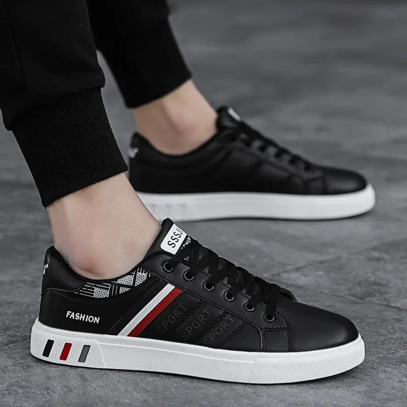 Men’s leather low top sport fashion sneakers in black with white soles featuring red and gray side stripes and sport lettering.