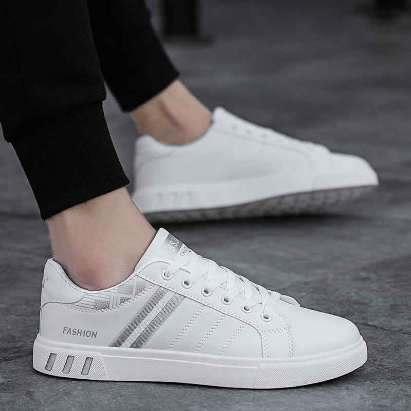 Men’s leather low top sport fashion sneakers in white with silver stripes and fashion branding on the side.