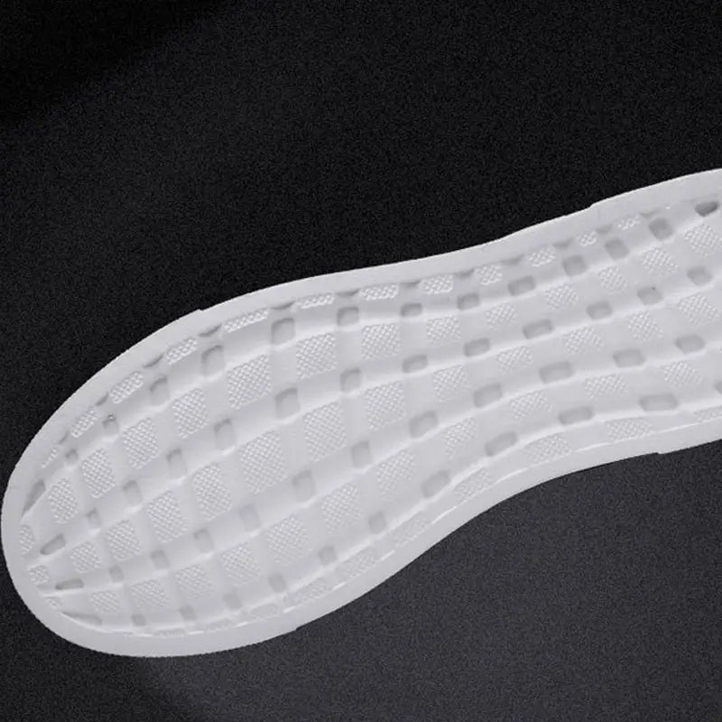 white rubber shoe sole with a textured grid-like pattern on men’s leather low top sport fashion sneakers.