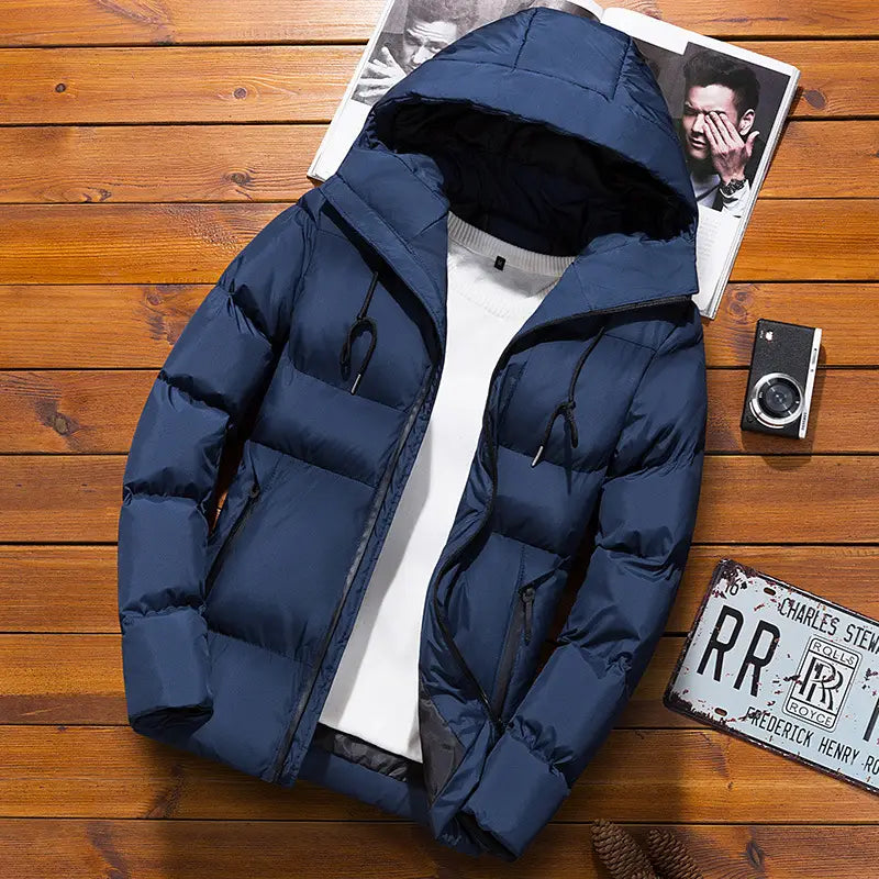 Chaqueta acolchada tipo puffer azul marino para hombre con capucha, con cierre mediante cremallera y cordones negros, mostrada desde el lado posterior.