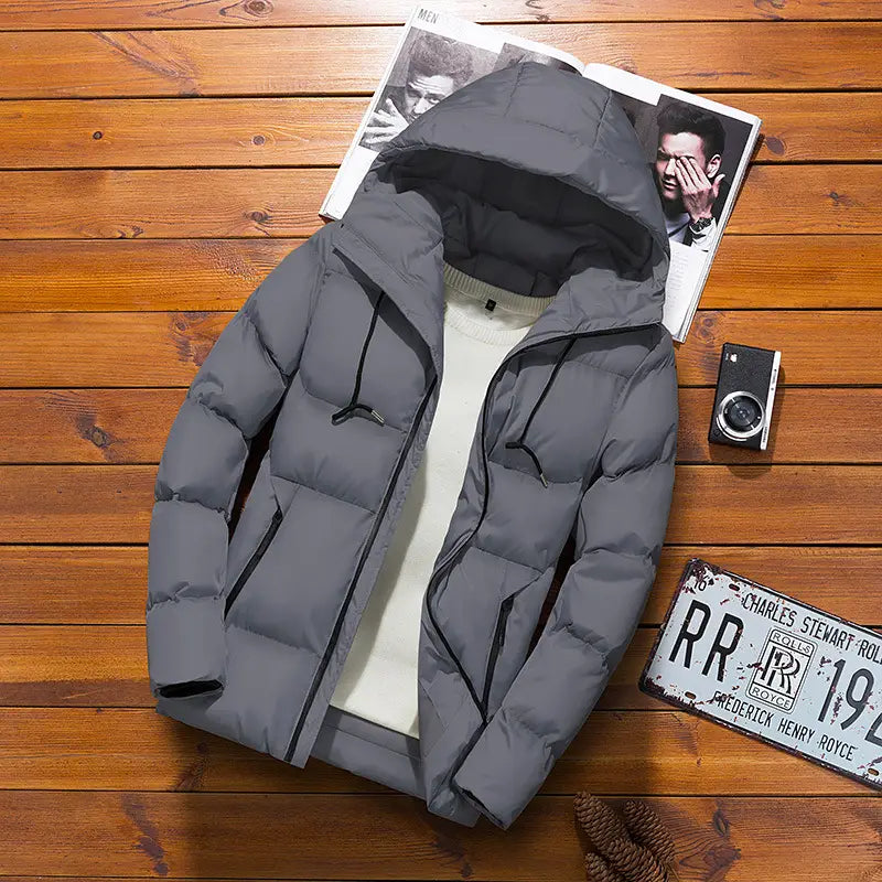 Chaqueta acolchada tipo puffer gris para hombre con capucha, con detalles en negro en la cremallera y cierre mediante cremallera.