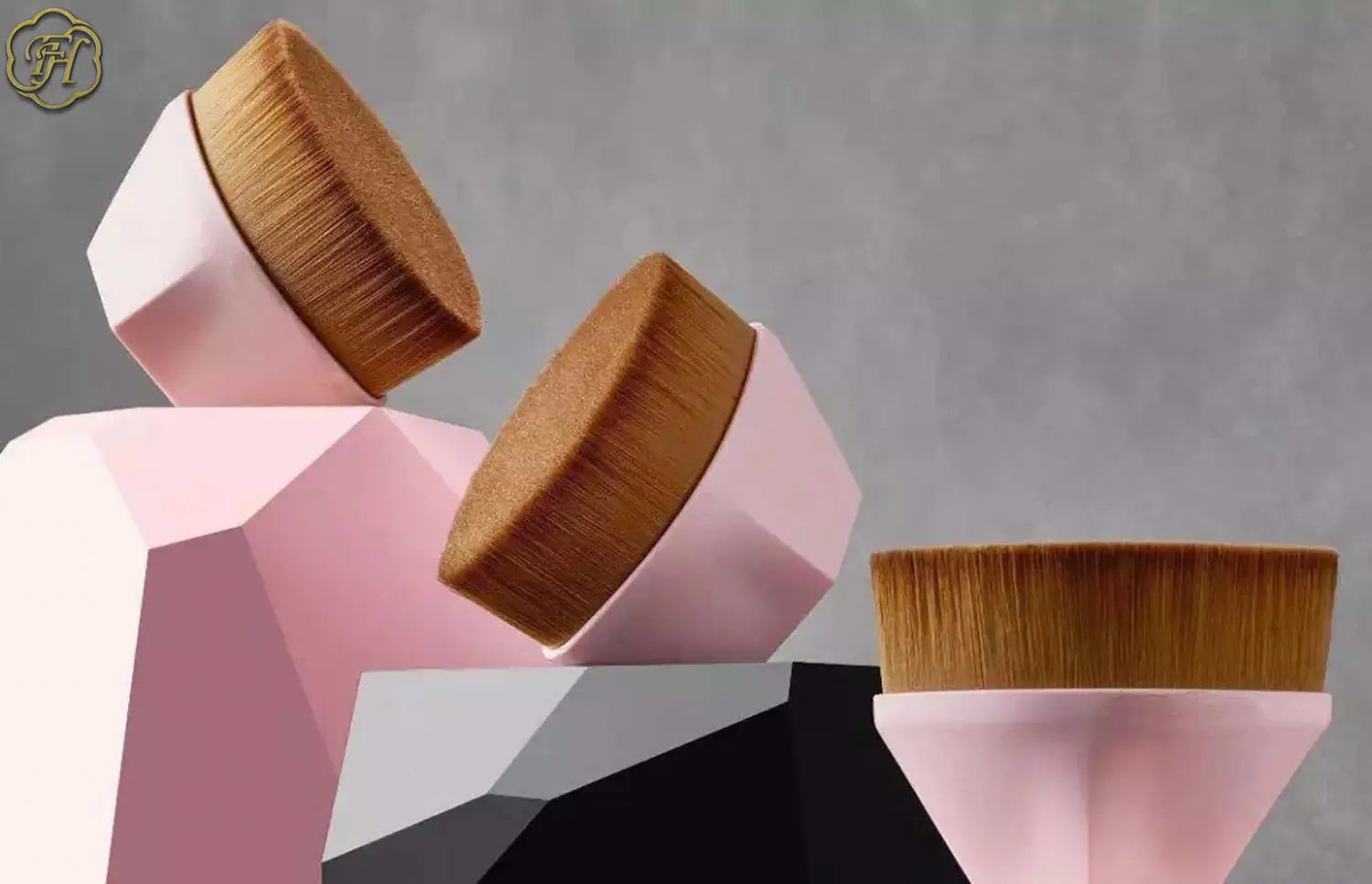 Pink geometric foundation brush and powder makeup set with brown bristles designed for precise application and included in a matching case.