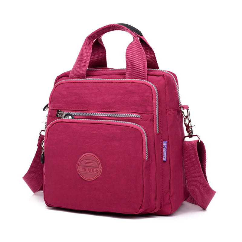 A vibrant fuchsia multi-functional nylon crossbody bag 25cm with structured design, multiple zippered compartments, and sturdy handles.