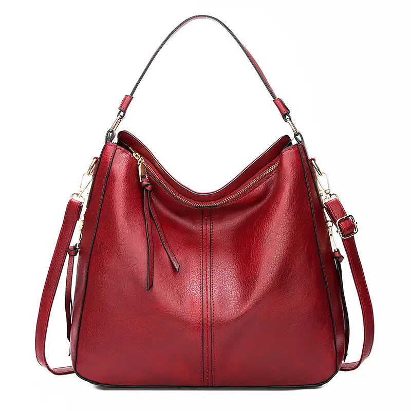 Red leather faux leather large capacity zippered hobo shoulder bag with single shoulder strap and adjustable crossbody strap.