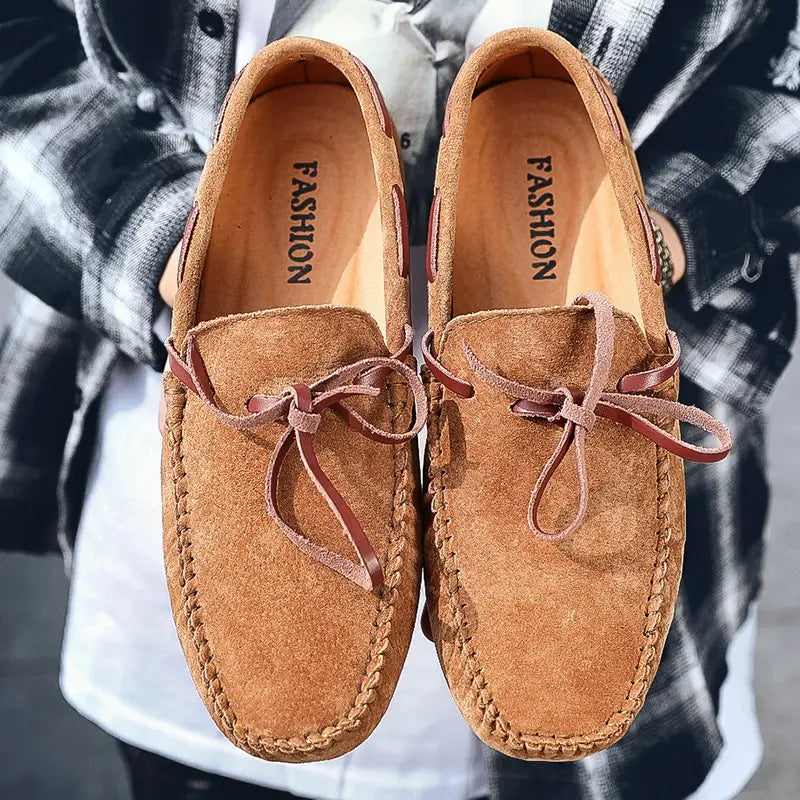 Des mocassins décontractés en suède camel pour la conduite, avec des lacets en cuir marron et des finitions cousues.