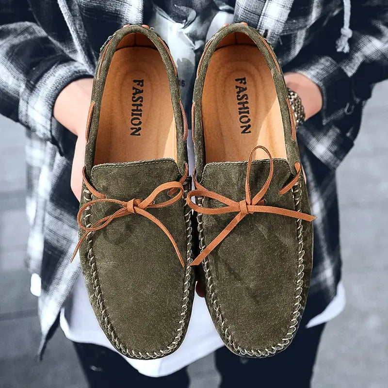 Des mocassins décontractés en suède vert olive pour la conduite, avec des lacets en cuir camel et des détails de couture.
