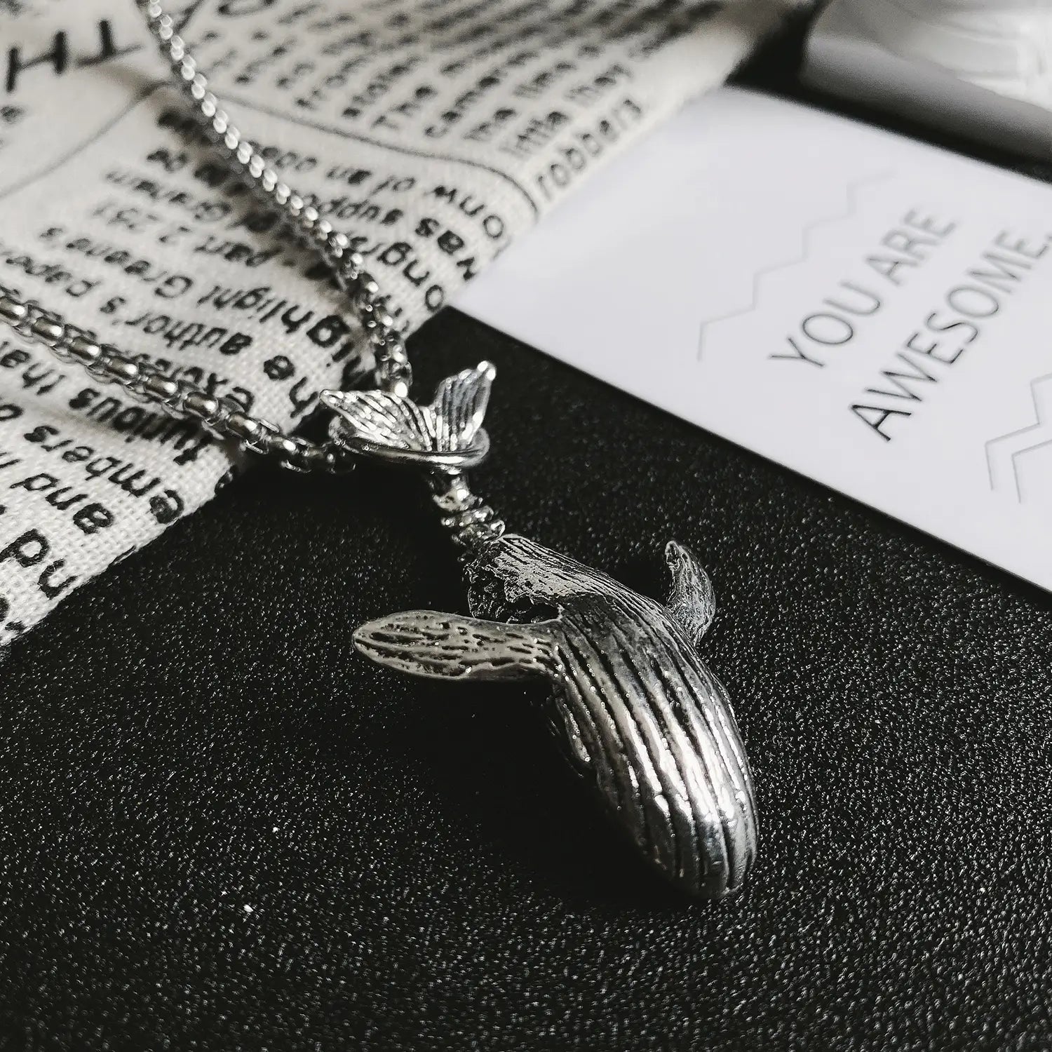 Silver whale pendant necklace in titanium steel with detailed textured skin and a delicate chain for hip hop style.