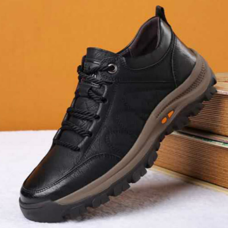 Men’s leather hiking shoe in black with a rugged tan rubber sole and orange accent details designed for vintage casual footwear.