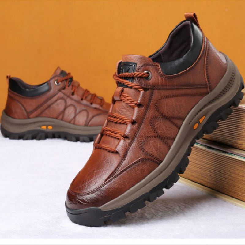 Men’s leather hiking shoe in brown with orange laces and a rugged rubber sole designed for vintage casual footwear.