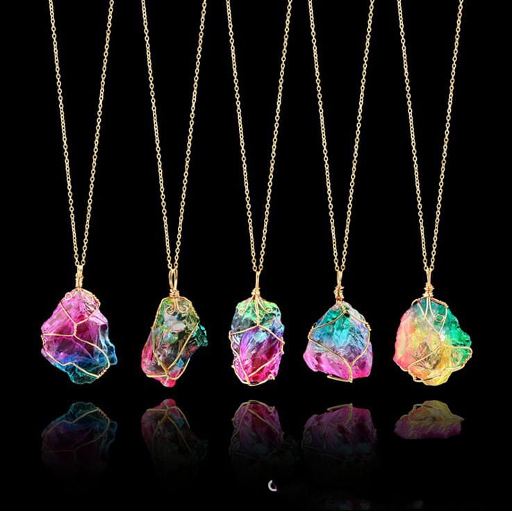 five colorful wire-wrapped raw crystal rainbow quartz pendants hanging from delicate gold-toned chains in a wire wrapped rainbow quartz crystal pendant necklace