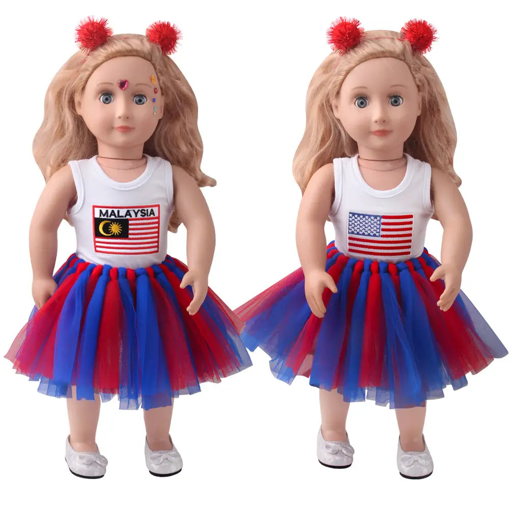 Zwei 18-Zoll-Puppen mit blondem Haar tragen passende weiße Tanktops mit USA- und Malaysia-Flaggenmotiven sowie rote und blaue, mehrlagige Tüll-Tutu-Röcke mit flauschigen roten Pom-Pom-Haaraccessoires.