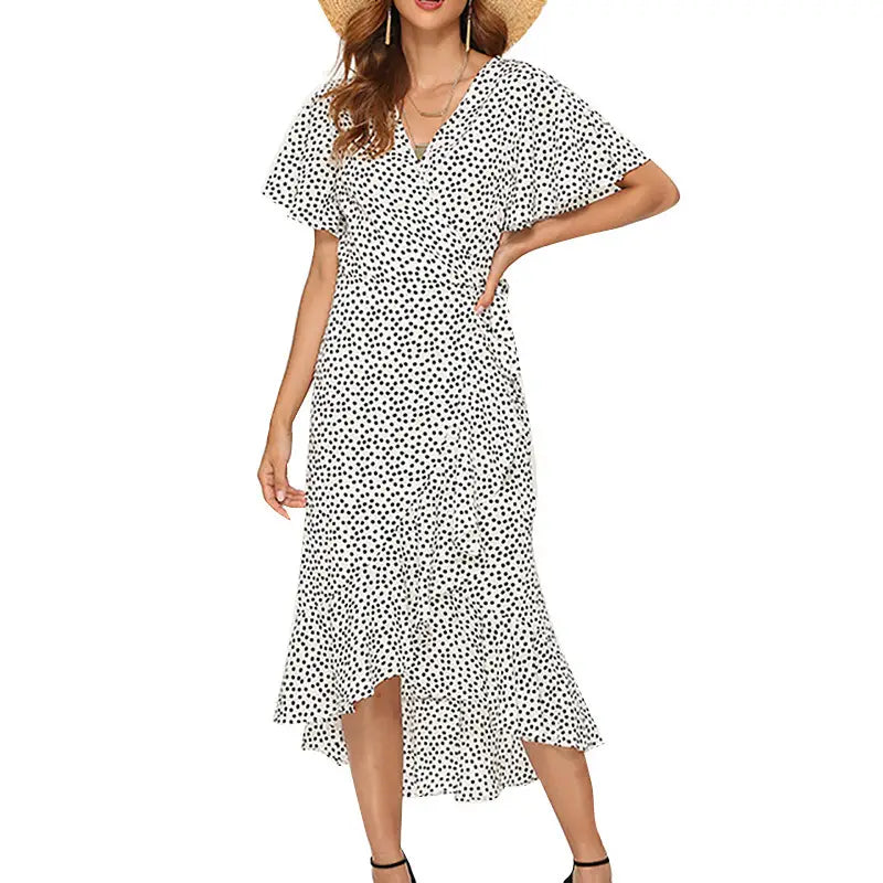 A white chiffon maxi dress with black polka dots featuring a v-neckline and short flutter sleeves in a floral style.