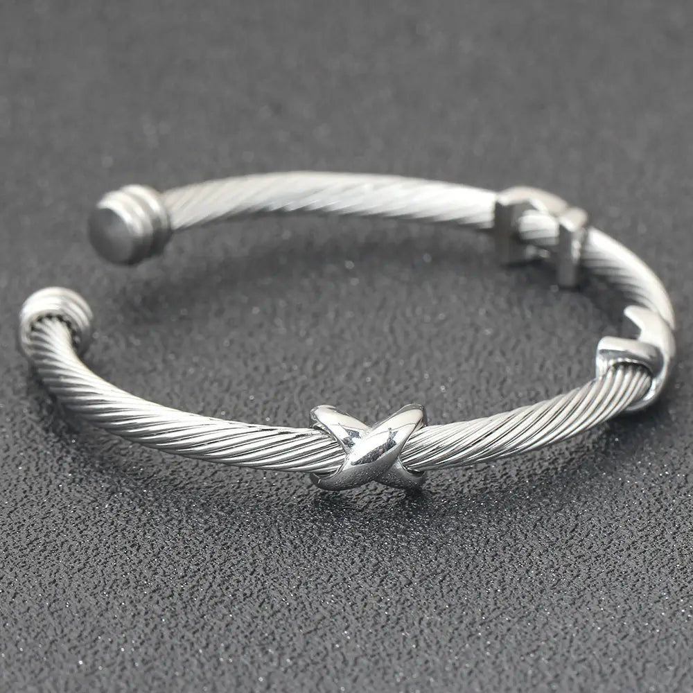 Silver twisted cable bracelet with an x-shaped knot clasp made of adjustable titanium steel.