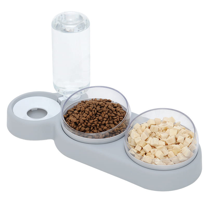 Grauer automatischer Tierfutter- und Wasserspender als Doppelschale mit zwei klaren Schalen, gefüllt mit braunem Trockenfutter und hellen Snacks, sowie einer transparenten Wasserflasche oben.