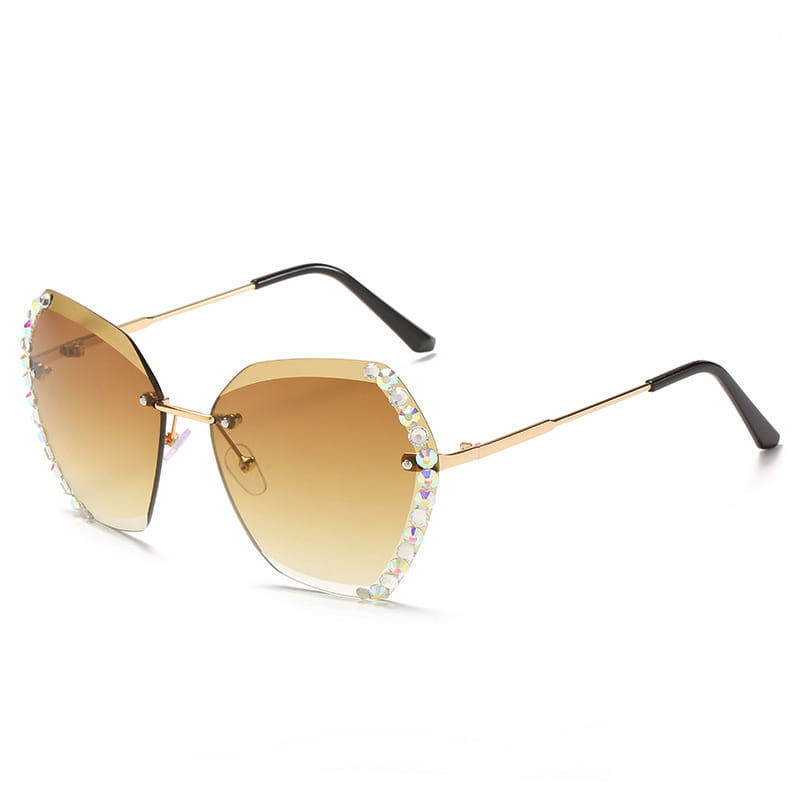 Diamond studded rimless polygonal sunglasses feature gold-rimmed frames with gradient brown lenses and a decorative border of sparkling rhinestones.