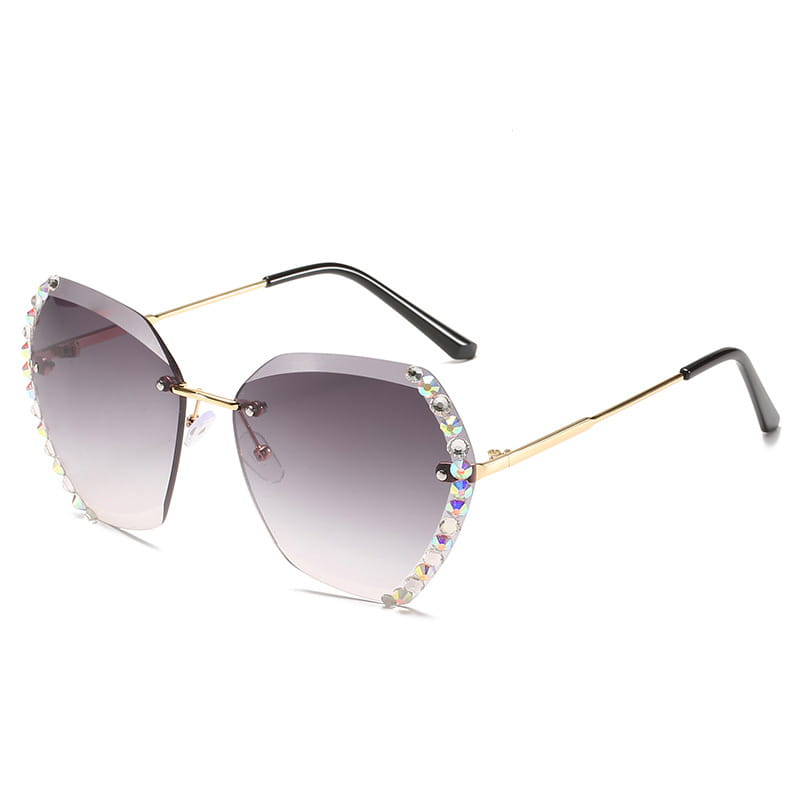 Diamond studded rimless polygonal gradient sunglasses featuring gold-rimmed cat-eye frames with gradient gray lenses and sparkling rhinestone embellishments along the edges.
