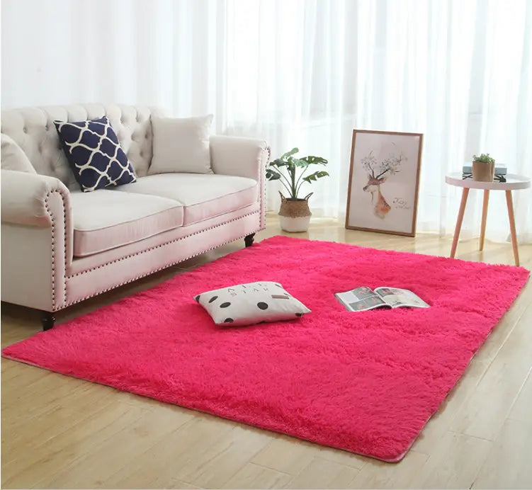 Una alfombra shaggy esponjosa de color rosa vibrante con textura de pelo sintético suave y lavable a máquina para un cuidado sencillo.
