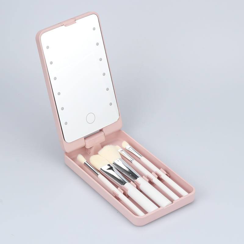 Led makeup mirror with folding brush set case in pink featuring a compact design with a mirrored lid and embedded led lights for enhanced makeup application.