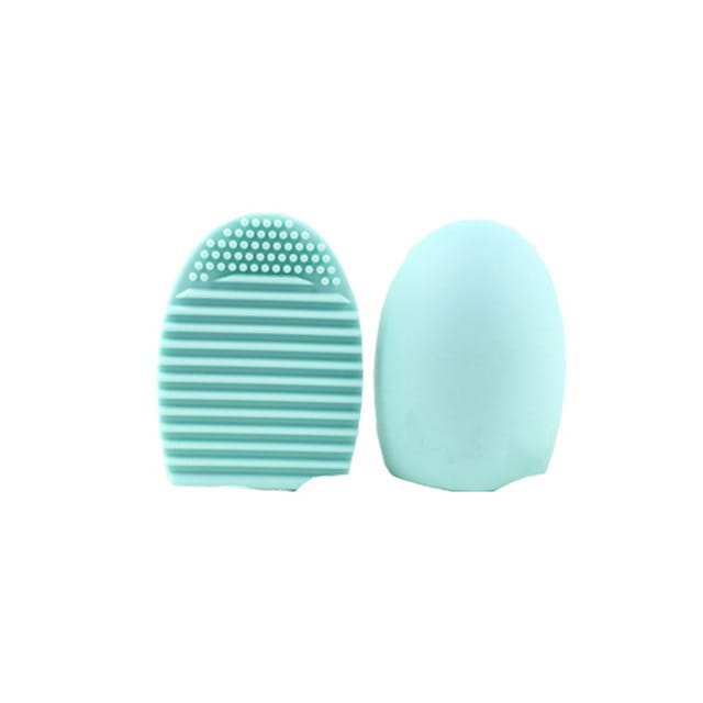 Mint green silicone eyelash and eye makeup remover brush with textured bristles shown from the back side in a makeup brush cleaner silicone egg scrubbing tool.