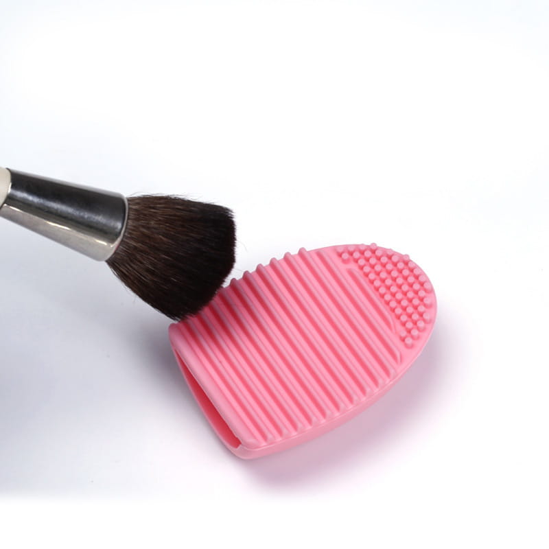 pink silicone makeup brush cleaner egg scrubbing tool with ridged and dotted texture for eyelash brush cleaning