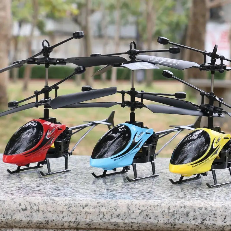 Trois jouets d’hélicoptère télécommandés pour enfants avec contrôle de la vitesse en rouge, bleu et jaune, présentant des cabines transparentes noires et des châssis métalliques affichés côte à côte.