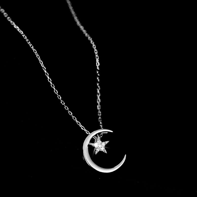 Sterling silver crescent moon and star pendant necklace with a delicate chain in silver color.