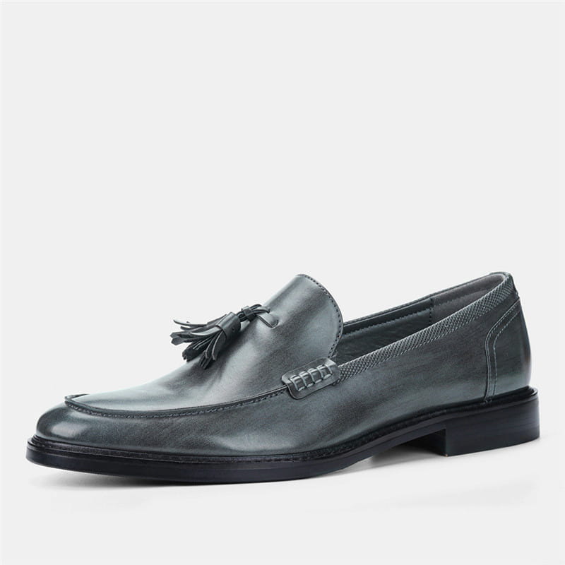 Men’s polished dark gray leather tassel loafers with stitched detailing and composite soles.