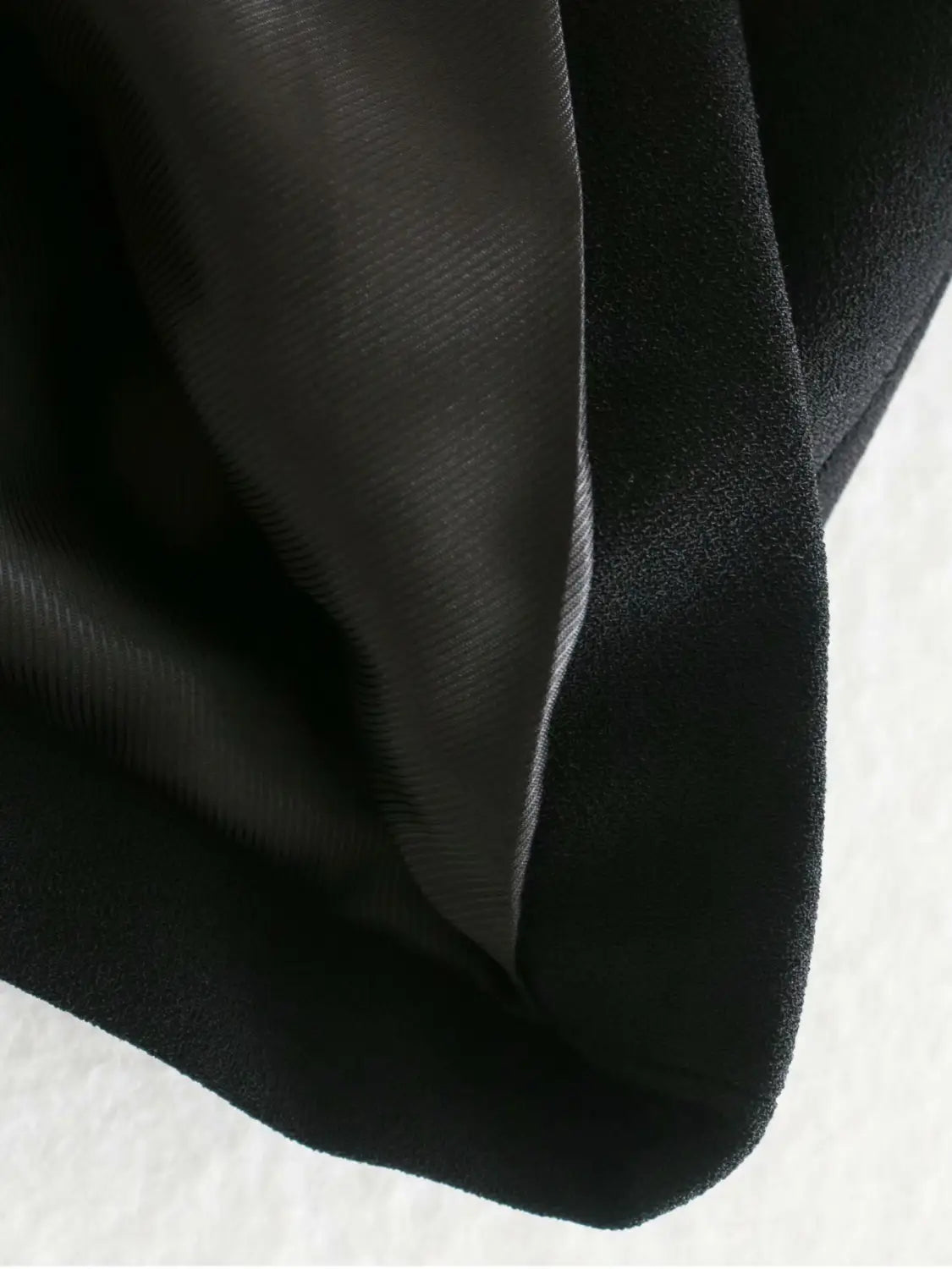 women’s tailored double breasted longline blazer coat in black satin fabric with a smooth glossy finish and subtle sheen