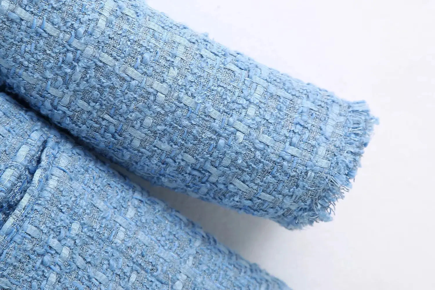 women’s double breasted light blue textured tweed blazer fabric showing a slightly frayed edge