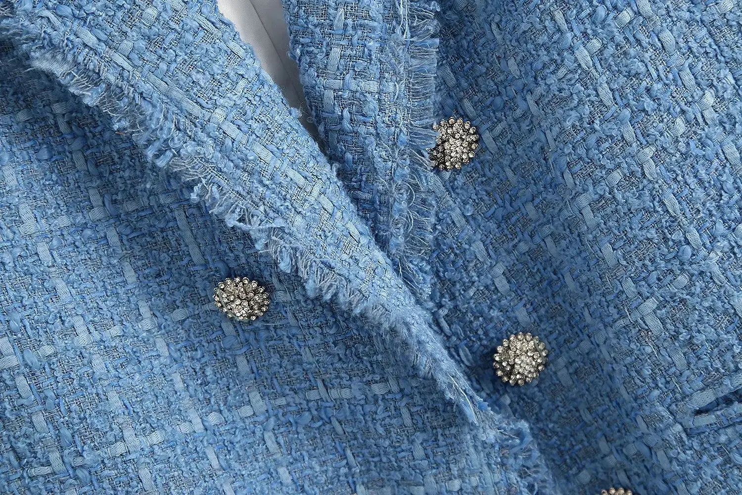 Women’s double breasted light blue textured tweed blazer featuring frayed edges and gold toned beaded buttons.
