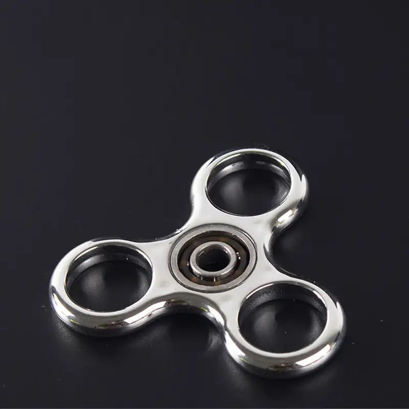 Silver three-pronged metallic led fidget spinner with a glow in the dark central bearing hand toy.