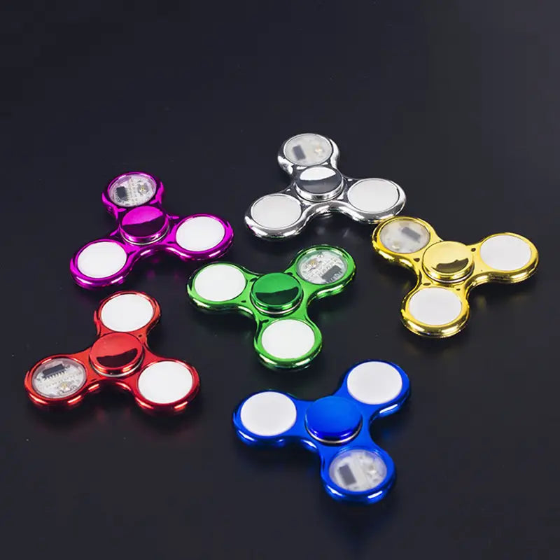 led fidget spinner glow in dark metallic hand toy featuring colorful metallic bodies with white circular ends and embedded led lights.
