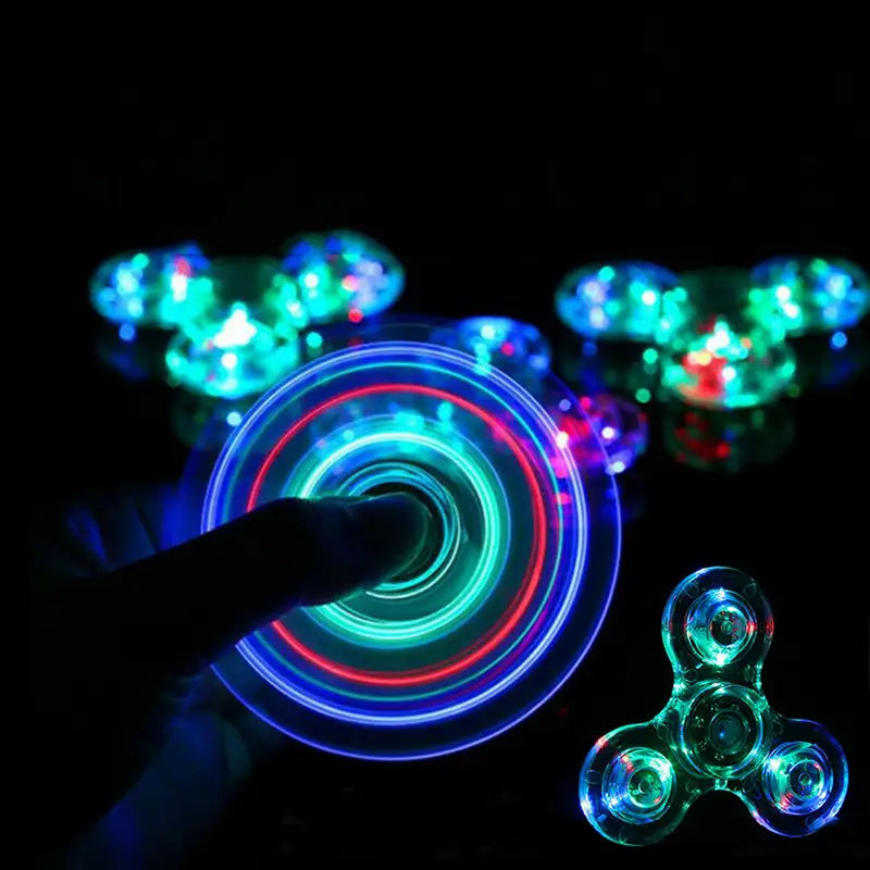 A glowing translucent led fidget spinner made of metallic material with vibrant blue and red lights spinning in a circular pattern designed as a glow in dark hand toy.