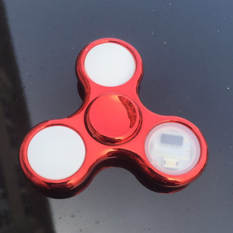Red metallic led fidget spinner glow in dark hand toy featuring three white circular sections with one containing a visible usb port.