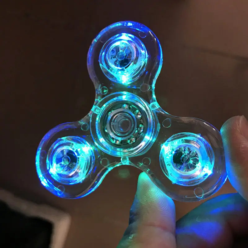 a translucent blue led fidget spinner with three arms and glowing lights designed as a glow in dark metallic hand toy