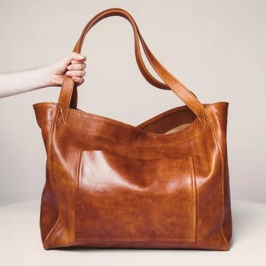 A tan oil wax leather tote shoulder bag with large capacity sturdy handles and a simple elegant design.