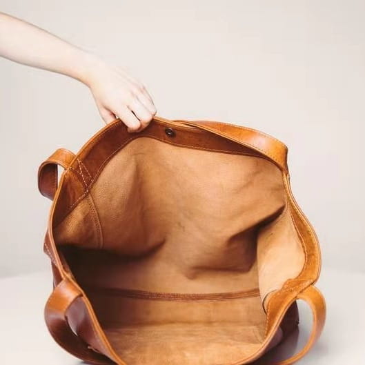 A tan oil wax leather tote shoulder bag with sturdy handles and a large capacity spacious interior.