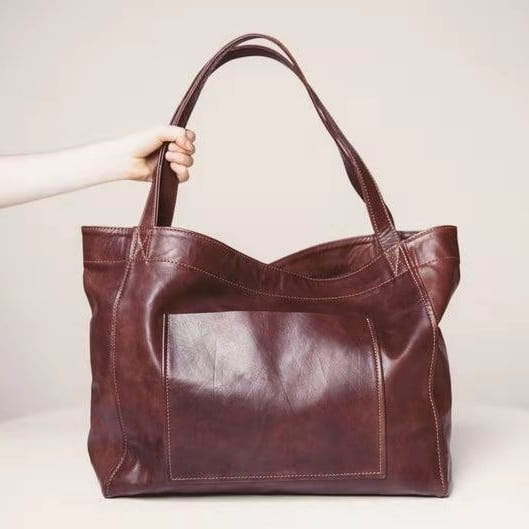 A large capacity oil wax leather tote shoulder bag in rich burgundy with sturdy handles and a front patch pocket.