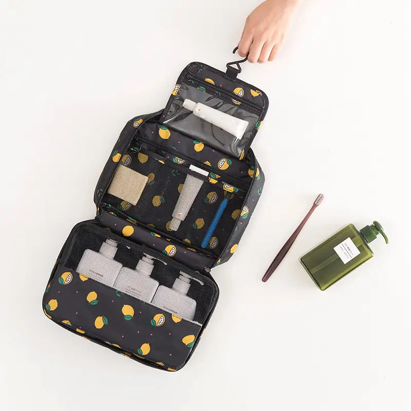 Schwarze Kosmetiktasche mit verspieltem Zitronenmuster, mit mehreren Fächern und Mesh-Taschen für eine geordnete Aufbewahrung von Reiseutensilien in einem hängenden Kulturbeutel-Organizer für Reise-Make-up.