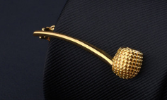 Gold-colored textured pipe-shaped pin from the men’s airplane tie clip and lapel pin gift set.